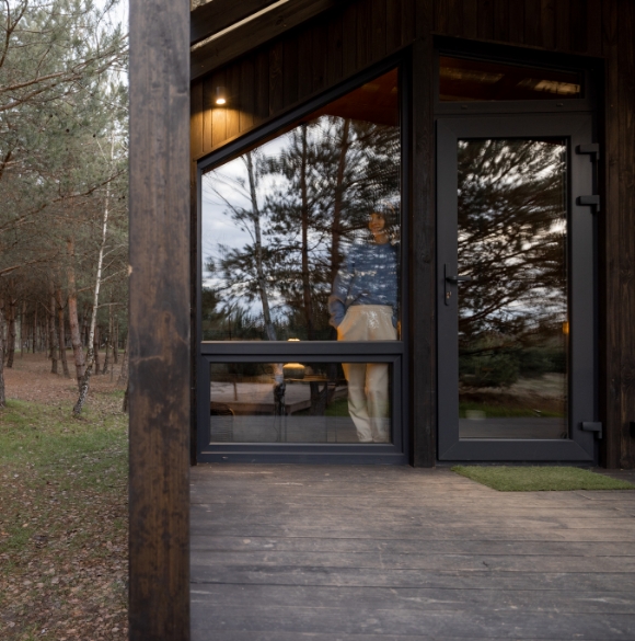 Benoit fortin rénovation | woman looks out the window at house in nature 2023 01 27 02 09 08 utc